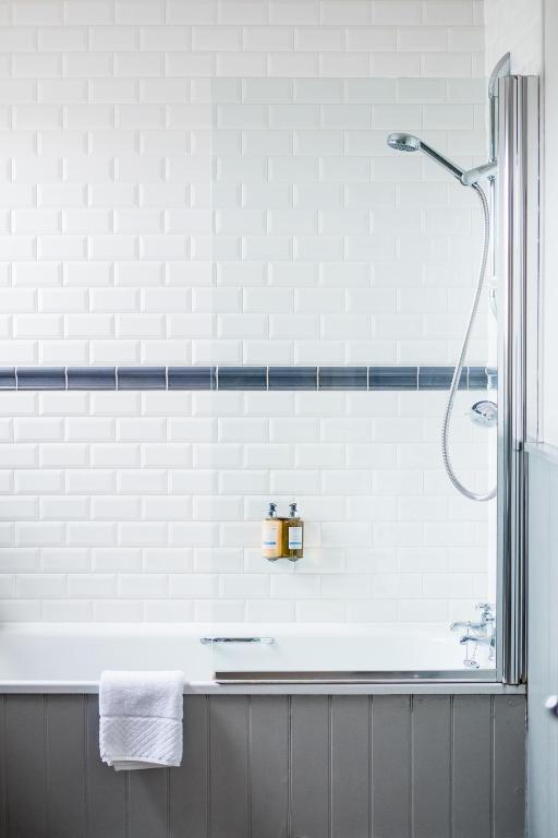 a bathroom with a shower and a tub at Crown Hotel in Southwold