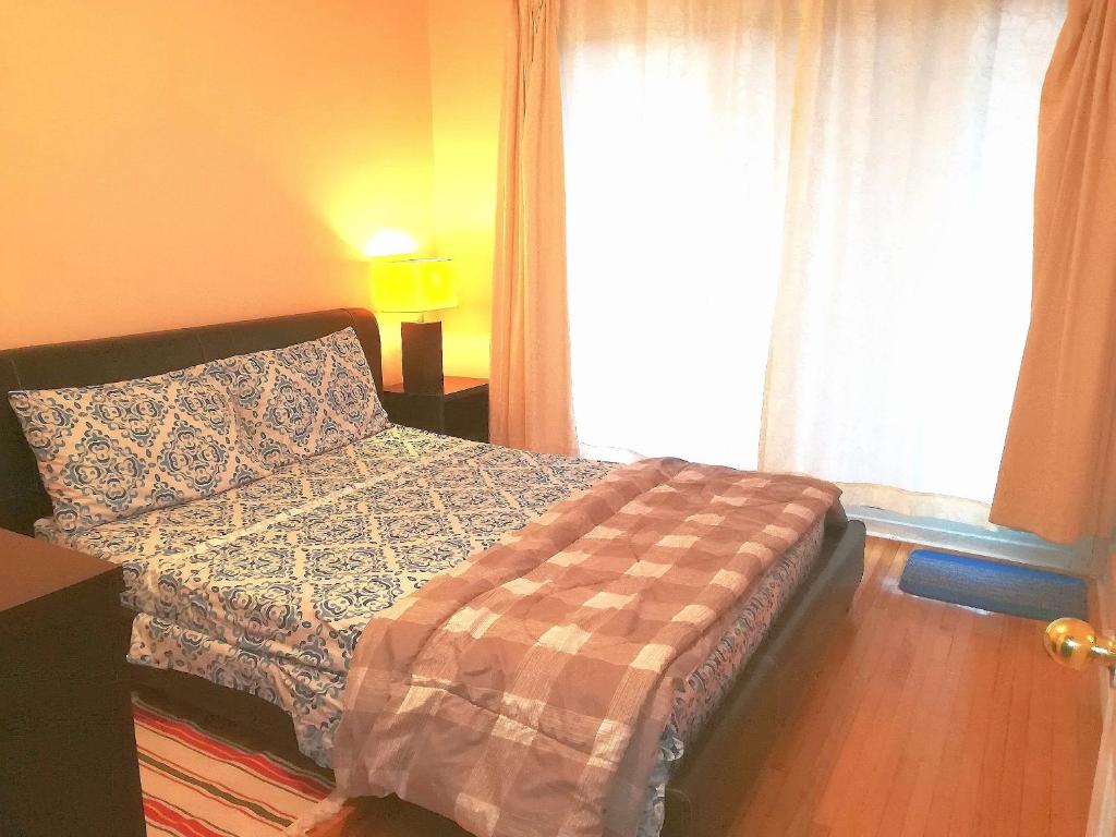 1 dormitorio con cama con almohada y ventana en Montreal Authentic appartment, en Montreal