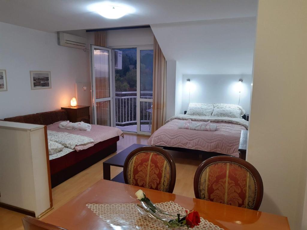 Zimmer mit 2 Betten, einem Tisch und Stühlen in der Unterkunft Sky Apartman in Sokobanja