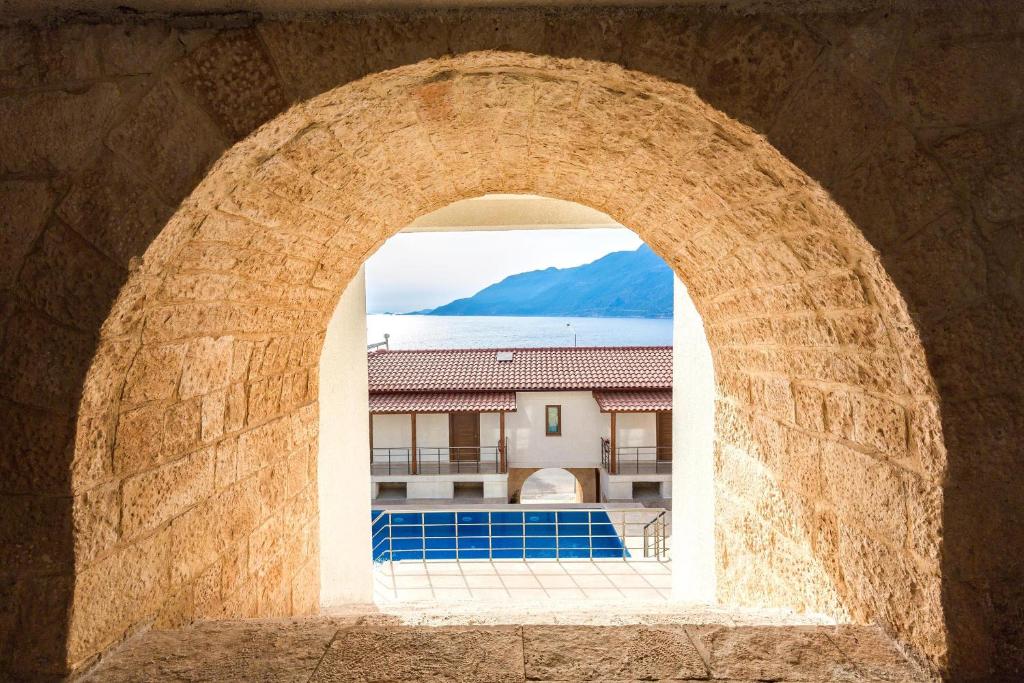 an archway with a view of a pool and a building at Medimar Hotel in Kaş