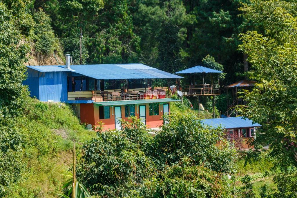 a house with a blue roof on top of a hill at Jungle Crown Organic Homestay in Nagarkot