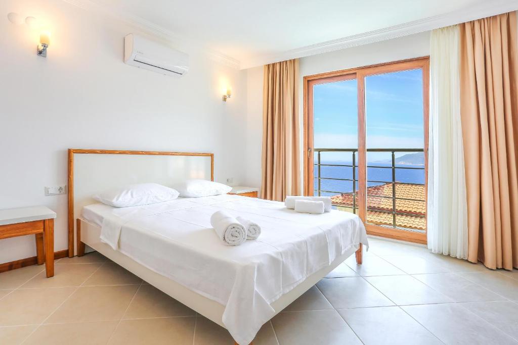 a bedroom with a bed with a view of the ocean at Medimar Hotel in Kaş