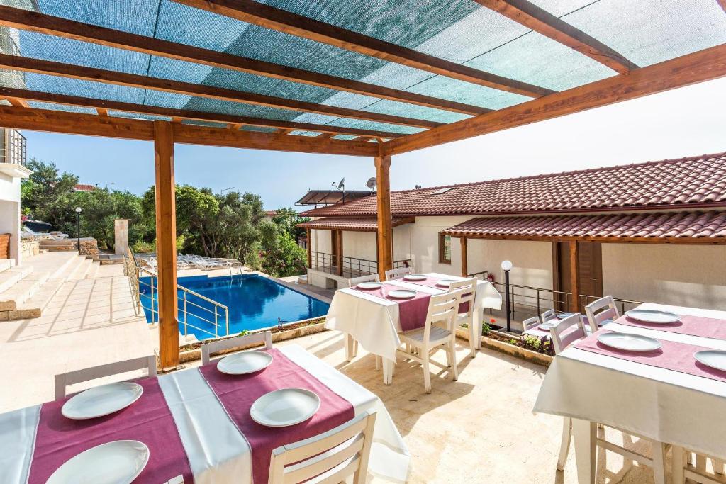 a patio with tables and chairs and a swimming pool at Medimar Hotel in Kaş