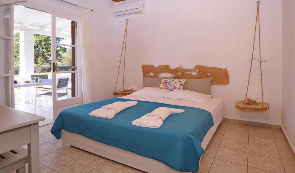 a bedroom with a bed with two towels on it at Serenity Apartments in Agios Georgios