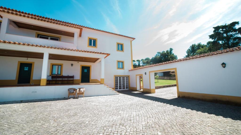 ein weißes Haus mit einer Terrasse und einer Auffahrt in der Unterkunft Quinta dos Lameiros in Vila Nova de Poiares