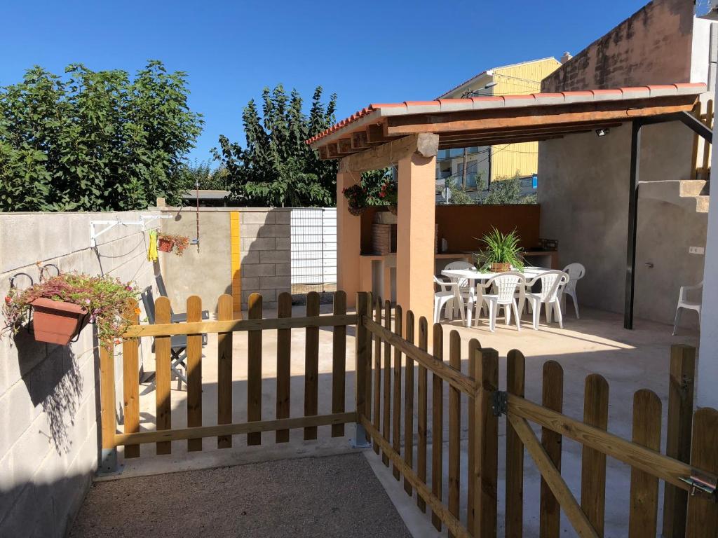 a wooden fence next to a patio with a table at Casa Sara in Deltebre