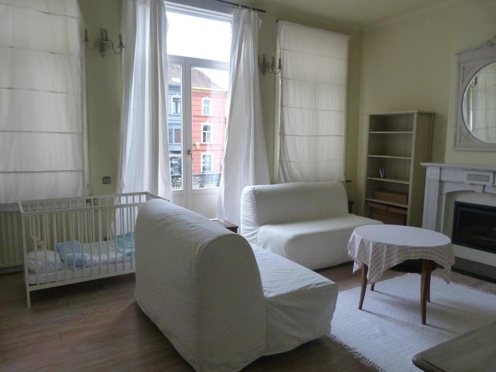 a living room with a couch and a crib at B&B Sparrow's Nest in Ghent