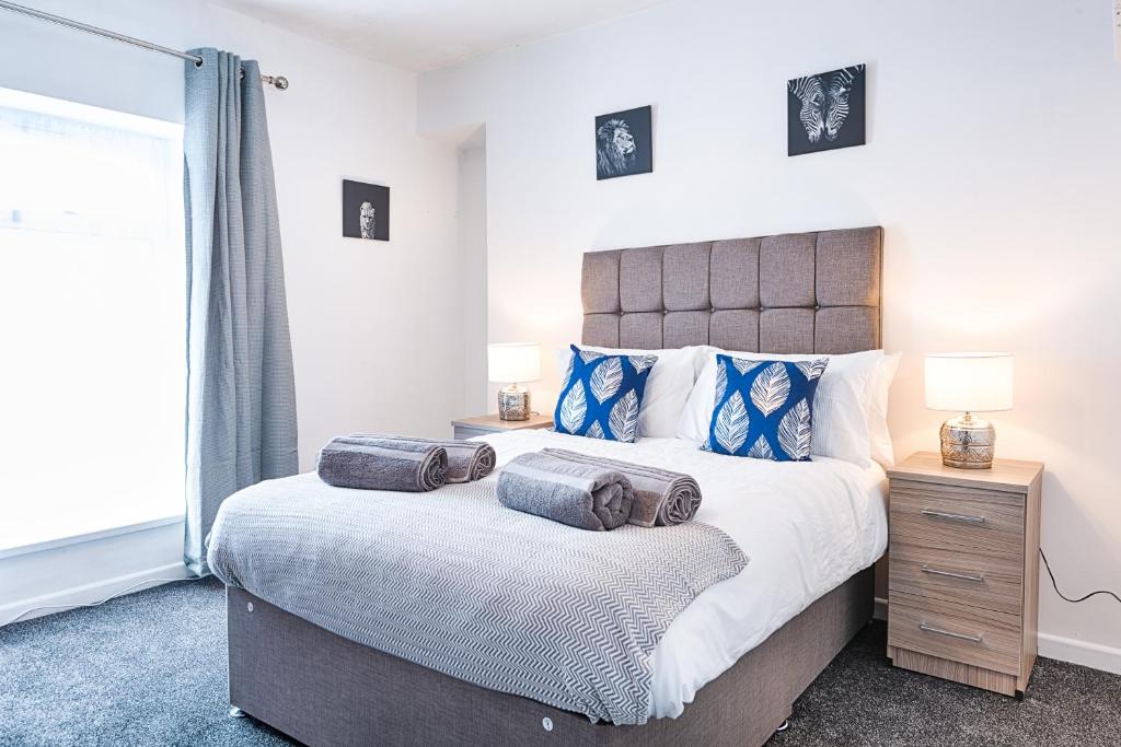 um quarto com uma cama grande com duas almofadas em Ideal location in Morriston! em Swansea