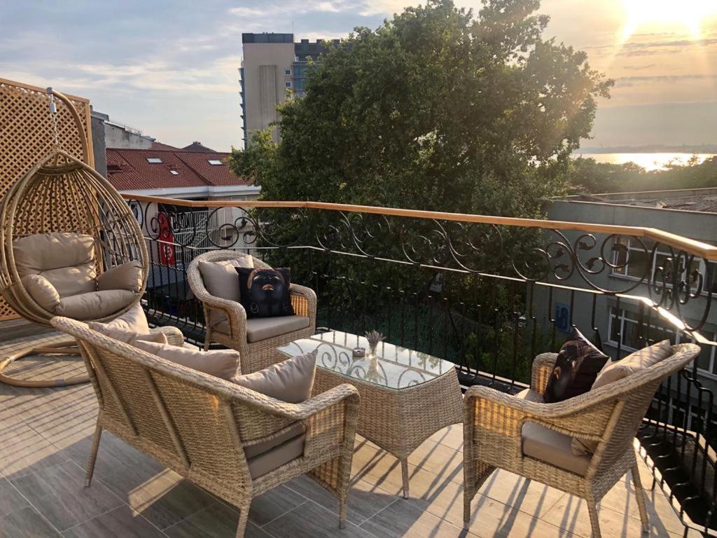 einen Balkon mit Korbstühlen und Möbeln auf einem Dach in der Unterkunft Red Stone Hotel in Istanbul