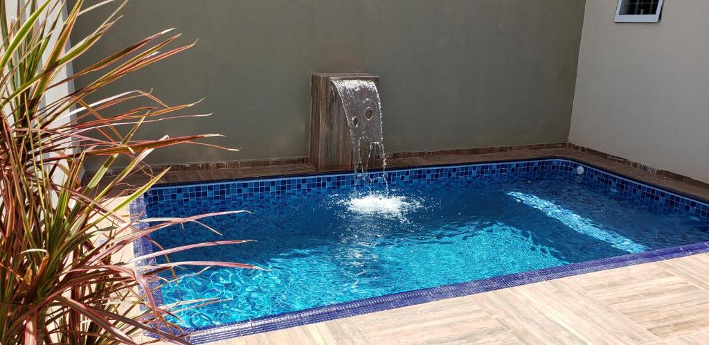 uma piscina com uma fonte de água num quarto em Casa Melo 6 em Olímpia