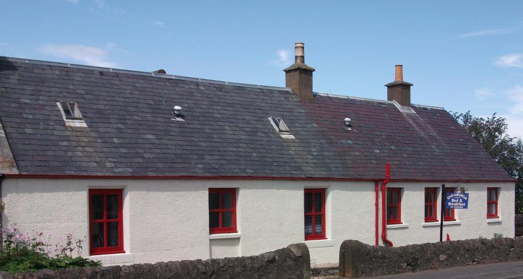 a white house with red windows and a roof at Osnaburgh B&B in Cupar