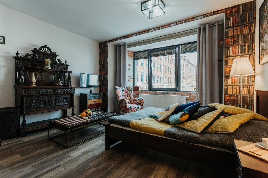 a bedroom with a bed and a living room at Singer Retro Studio in Kazimierz in Kraków