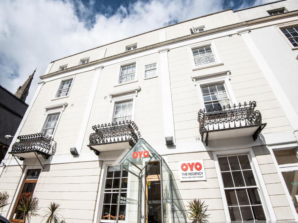 een wit gebouw met een aoops bord ervoor bij OYO the Regency, Clifton Bristol in Bristol