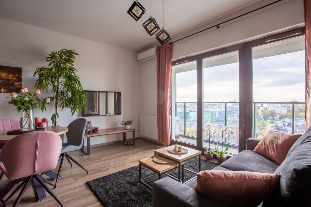 a living room with a couch and a table at Glamour Apartment City View in Wrocław