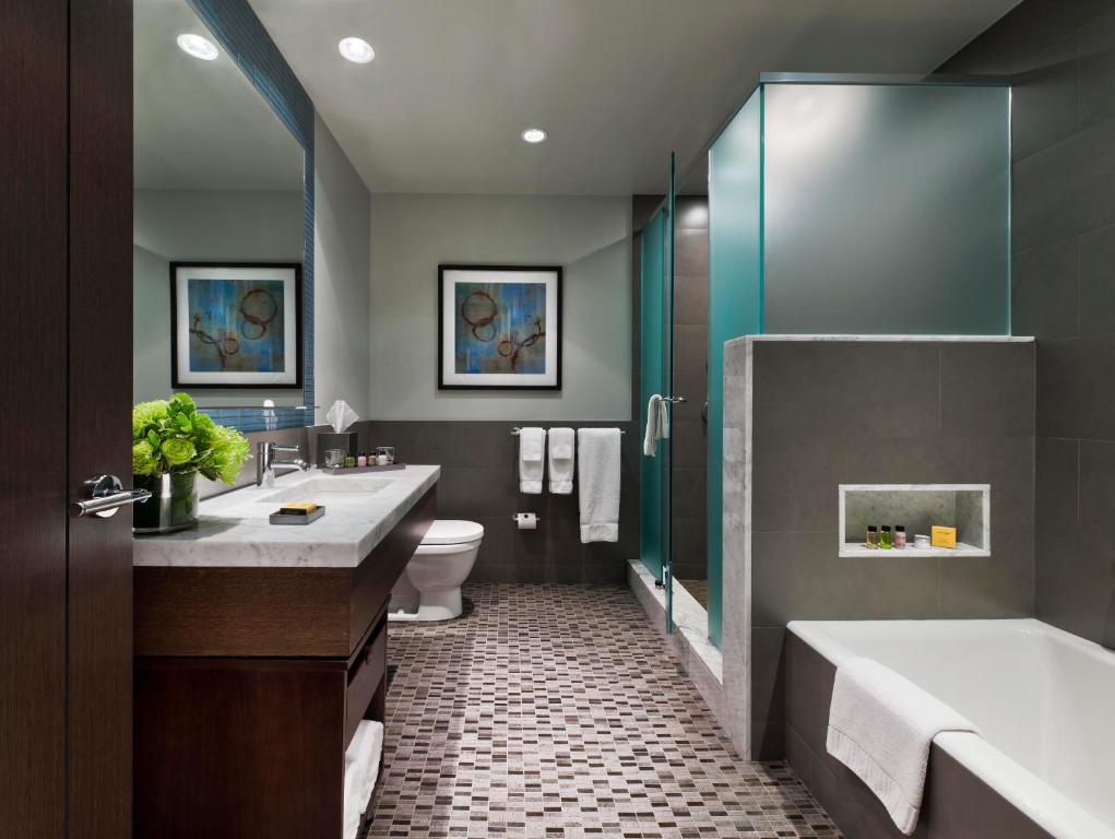 a bathroom with two sinks and a tub and a toilet at The Pearl Hotel in New York