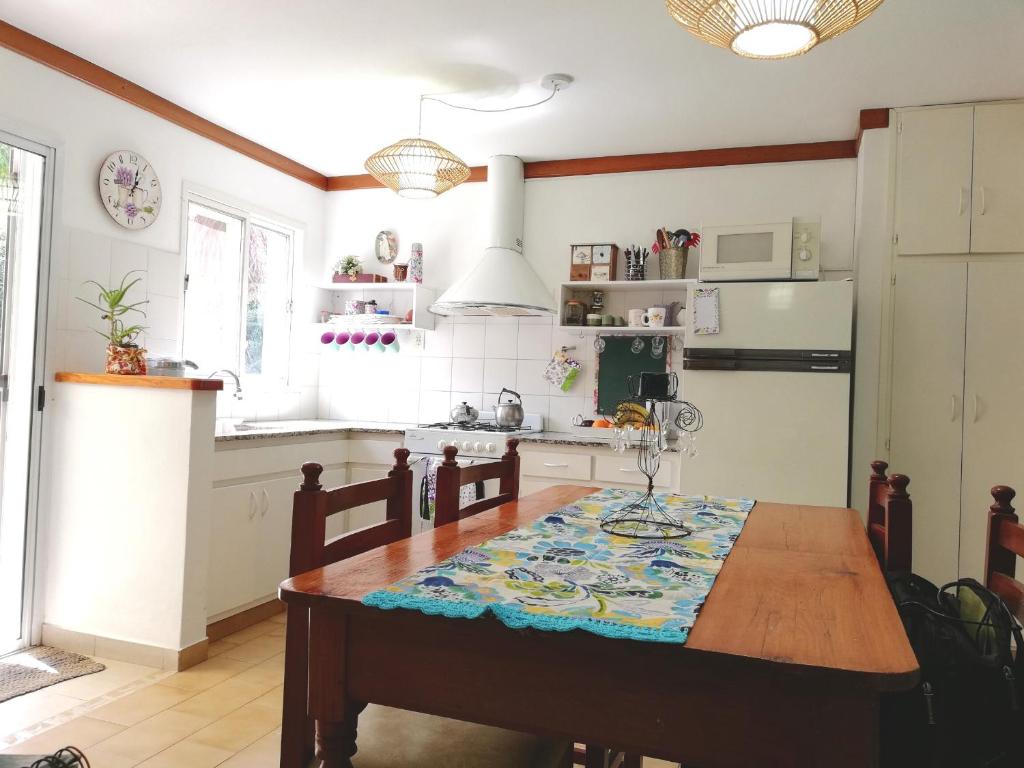 uma cozinha com uma mesa de madeira e uma sala de jantar em Alojamiento familiar em Coronel Suárez