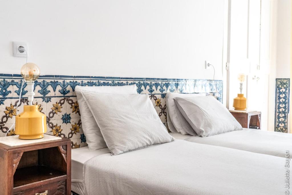 2 letti posti uno accanto all'altro in una camera da letto di Azulejos Cais Sodré B&B a Lisbona