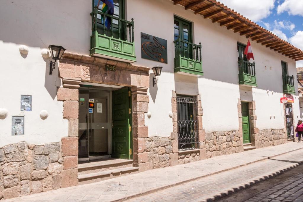 ein Gebäude mit grünen Türen und Fenstern auf einer Straße in der Unterkunft Usgar San Pedro Boutique in Cusco