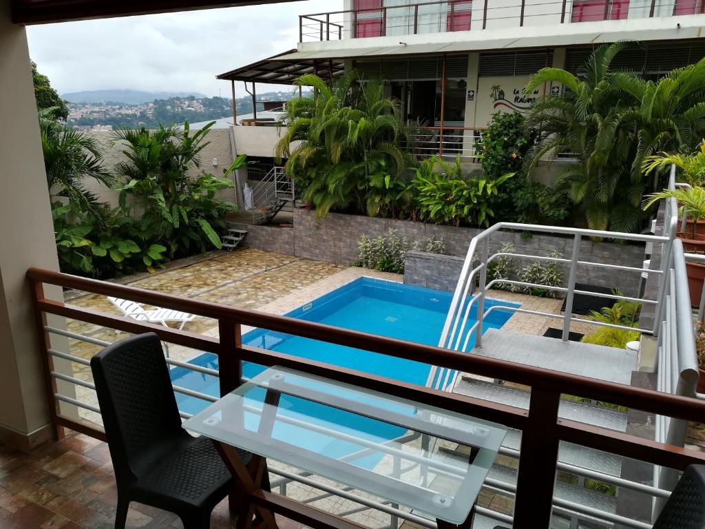 einen Balkon mit Pool, Tisch und Stühlen in der Unterkunft La Casa Del Italiano in Tarapoto