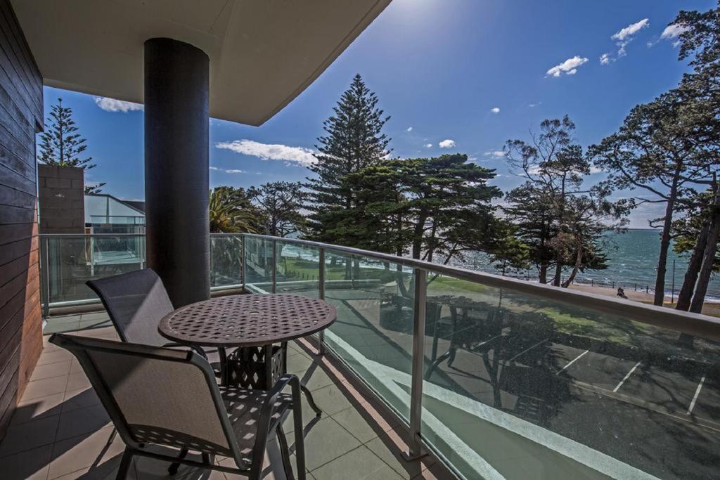 einen Tisch und Stühle auf einem Balkon mit Meerblick in der Unterkunft Phillip Island Holiday Apartments in Cowes