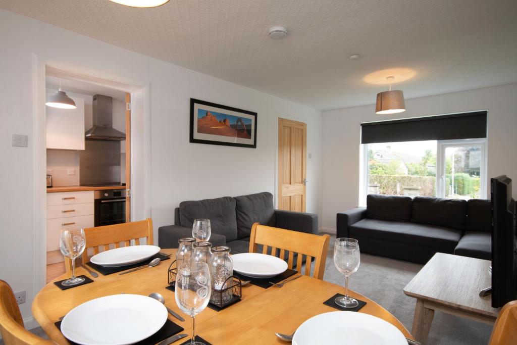 a dining room and living room with a table and chairs at Grampian Serviced Apartments - Park View in Elgin