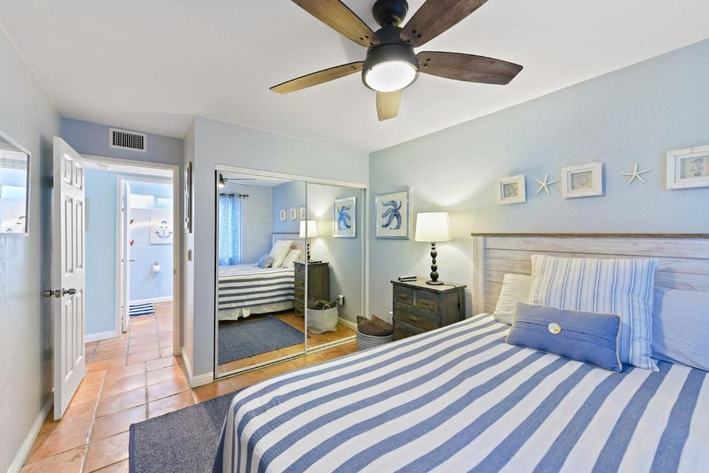1 dormitorio con 1 cama y ventilador de techo en Luna Azul, cozy condo only steps to Mission Beach! Free Internet, en San Diego