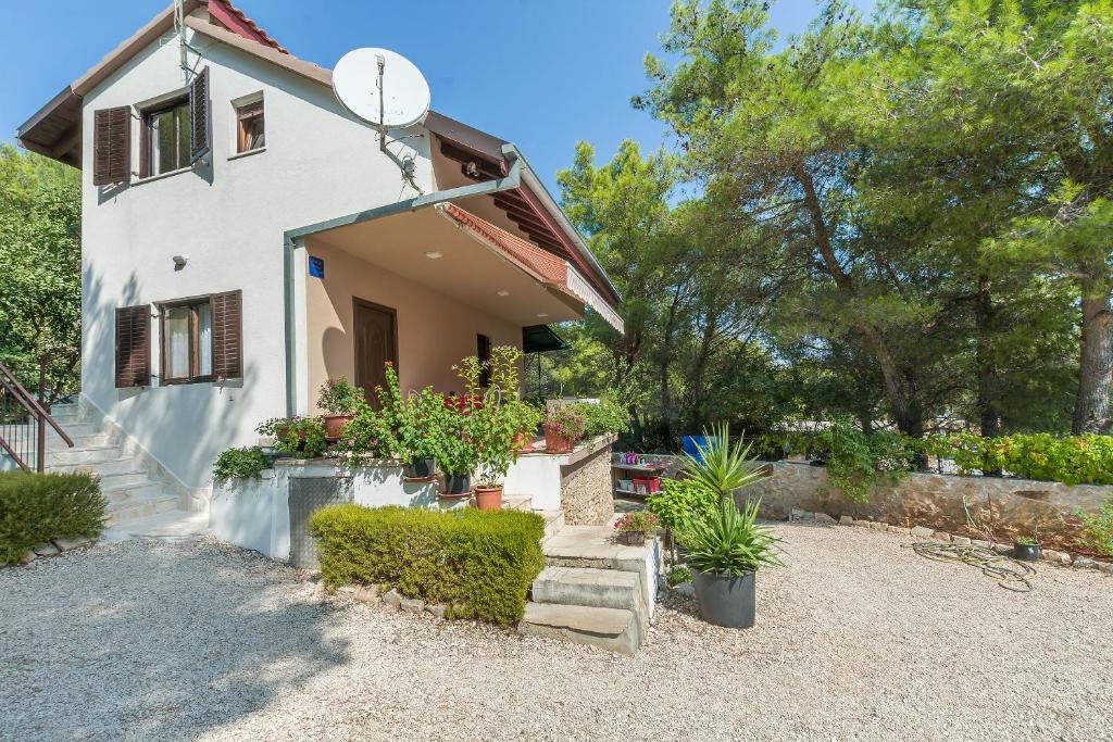 a white house with some plants in front of it at Apartment Ametist in Milna