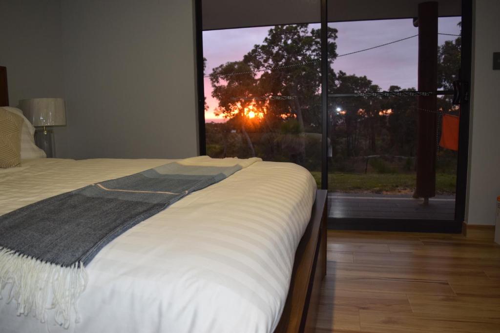 sypialnia z łóżkiem i dużym oknem w obiekcie Eagle Bay House w mieście Dunsborough