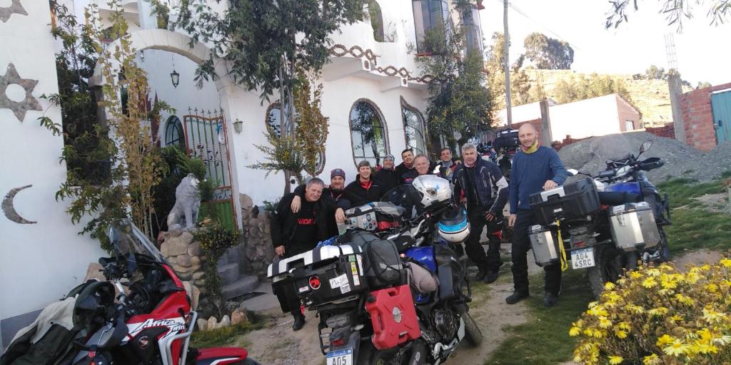 a group of people standing in front of a building with motorcycles at Hostal Piedra Andina in Copacabana