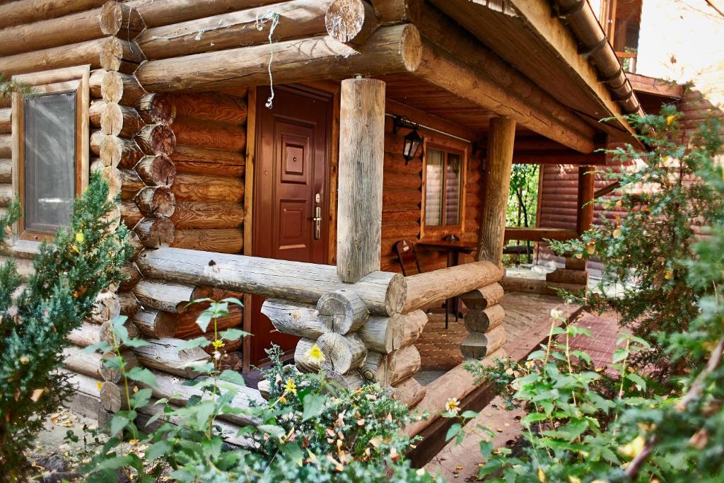 Blockhaus mit Veranda und Tür in der Unterkunft Zolotoy Bereg Hotel in Tschernihiw