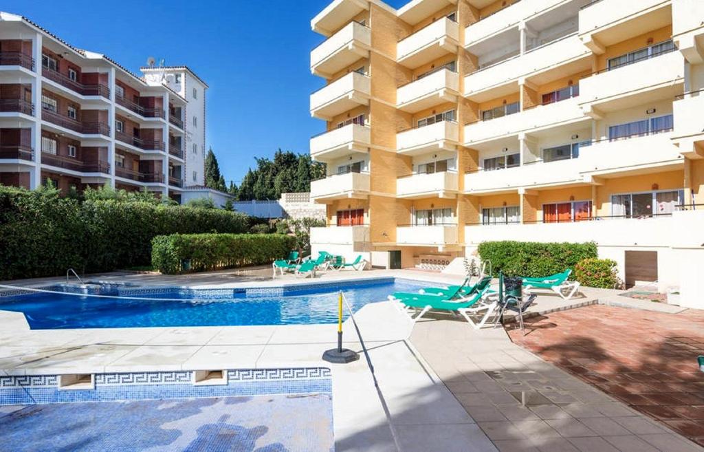 basen przed dużym budynkiem mieszkalnym w obiekcie Apartment Club Playa Flores Torremolinos w mieście Torremolinos