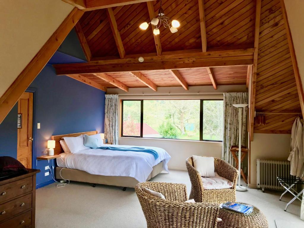 una camera da letto con un letto e una grande finestra di Murchison Lodge a Murchison