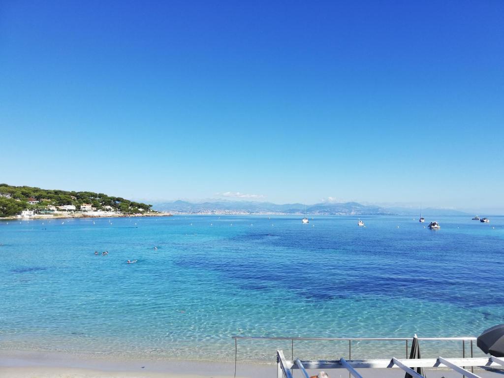 a view of a beach with boats in the water at Hotel Miramar- Cap d'Antibes - La Garoupe plage in Antibes