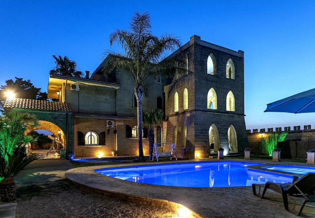 a house with a swimming pool in front of a building at Villa Full'House in Racale