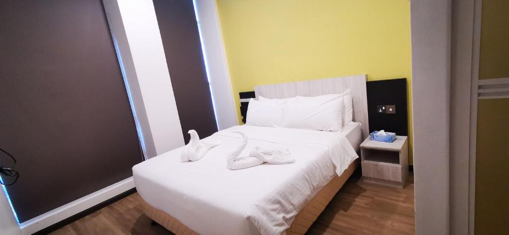 Postel nebo postele na pokoji v ubytování TT Dorf Hotel Taiping