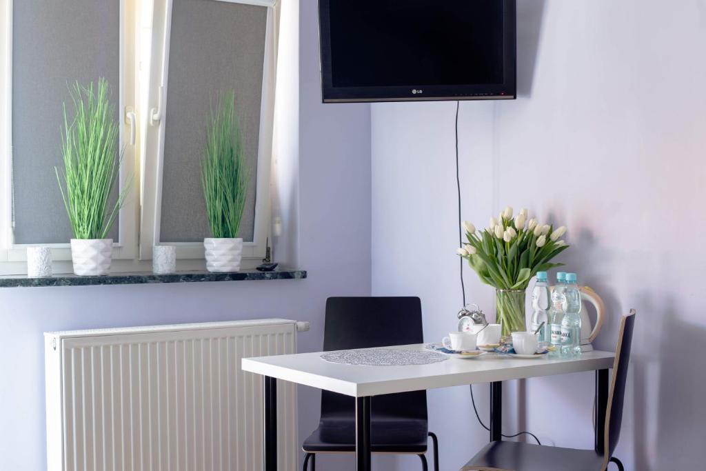 a white table with two chairs and a tv on a wall at Agroturystyka Krężniczanka in Lublin