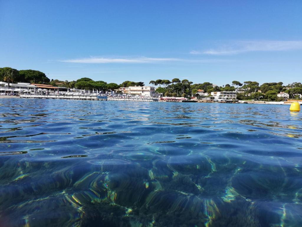 a view from the water of a beach at Hotel Miramar- Cap d'Antibes - La Garoupe plage in Antibes