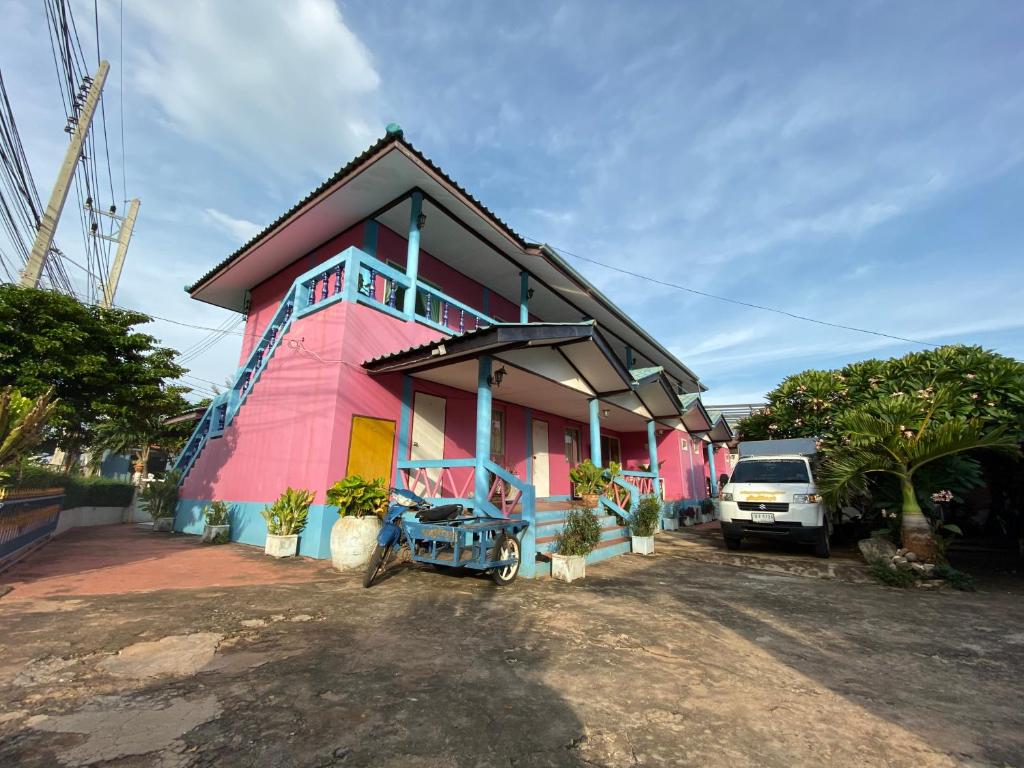 a pink house with a truck parked in front of it at Phuttharaksa Resort in Ko Larn