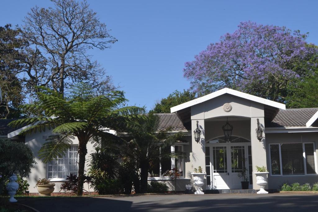 a white house with a palm tree in front of it at Retreat in Hillcrest