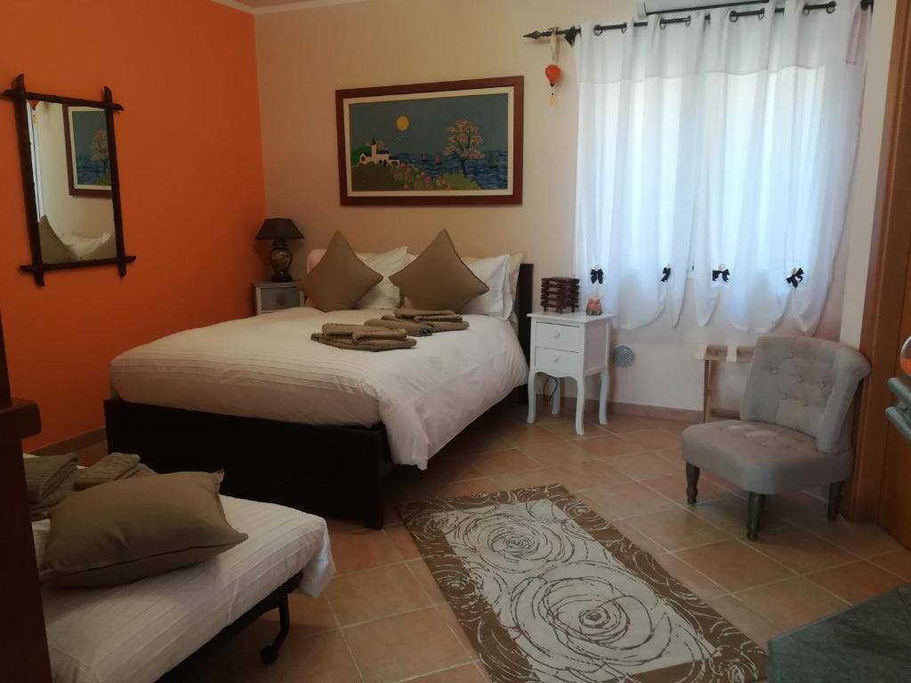 a bedroom with two beds and a chair and a mirror at Casarina in Ventimiglia