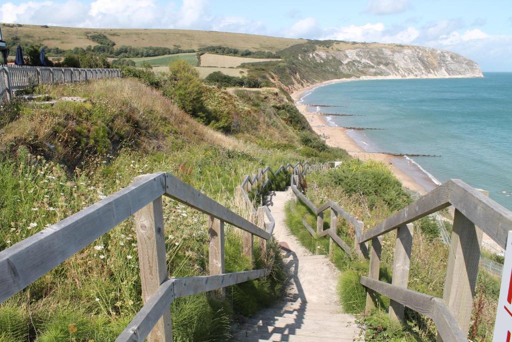 a staircase leading down to a beach with the ocean at The Pines Hotel in Swanage