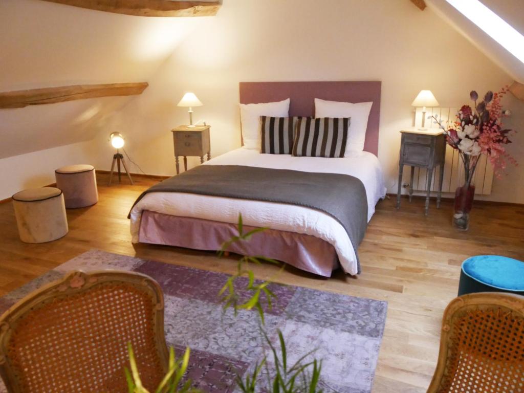 sypialnia z dużym łóżkiem z 2 stołami i 2 krzesłami w obiekcie Le champ de l'eau w mieście Crecy la Chapelle