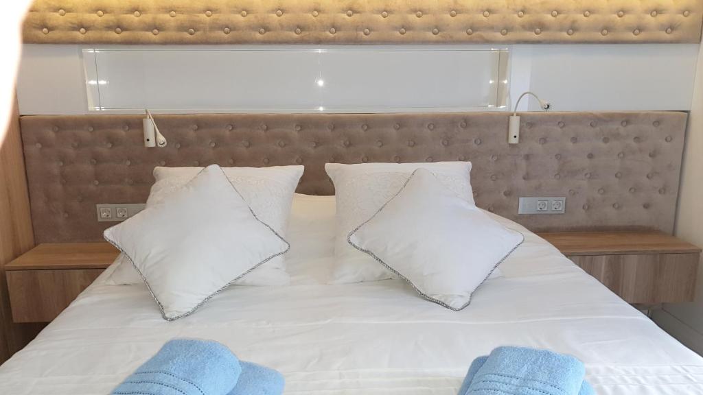 a bed with white pillows and blue towels on it at Blue Seaside Apartment in Gdańsk