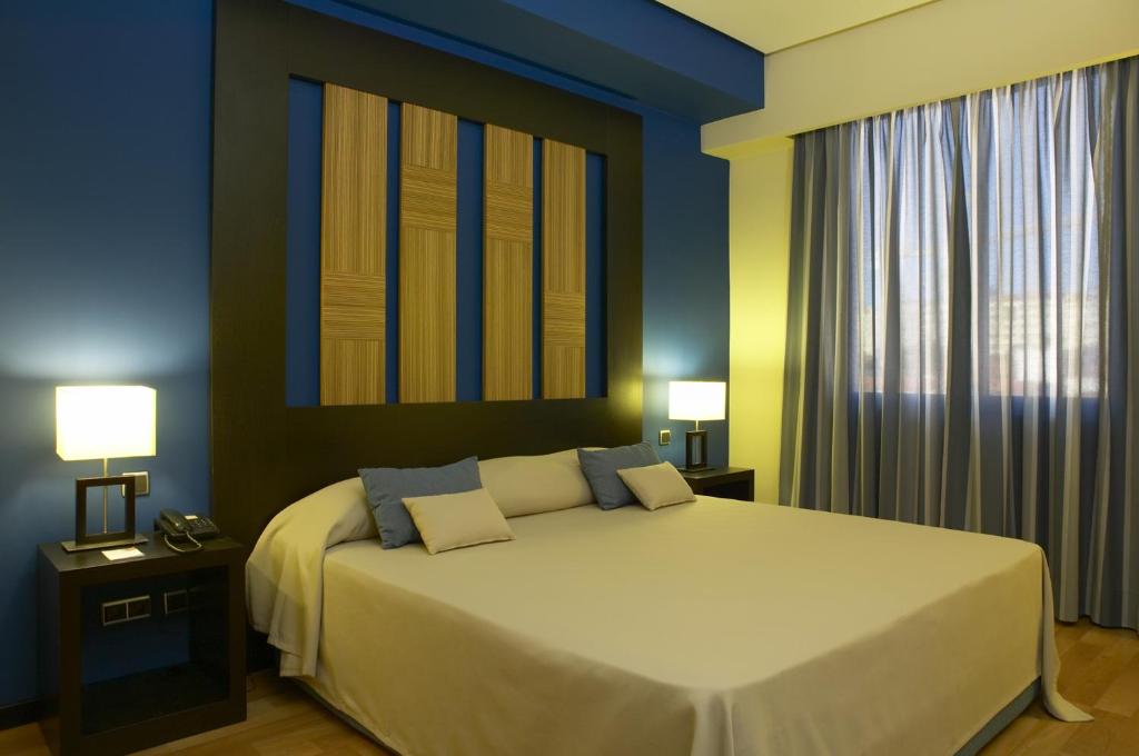 a bedroom with a large bed and two lamps at Hotel Lisboa in Lisbon