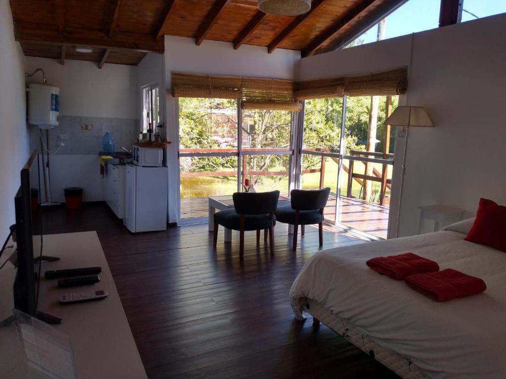 a bedroom with a bed and a table and chairs at Cabañas Burdeos in Tigre