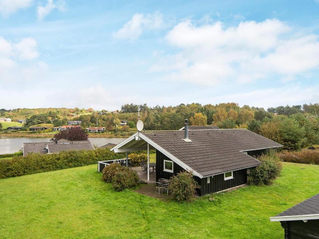 エーベルトフトにある8 person holiday home in Ebeltoftの川の横の草原の小屋