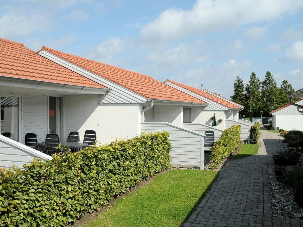 
a white house sitting in front of a building at Holiday Home Paradiset III in Ærøskøbing
