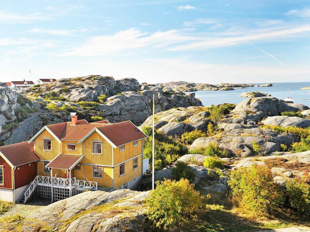12 person holiday home in Sk rhamn في سكارهامن: منزل على تلة صخرية مع المحيط