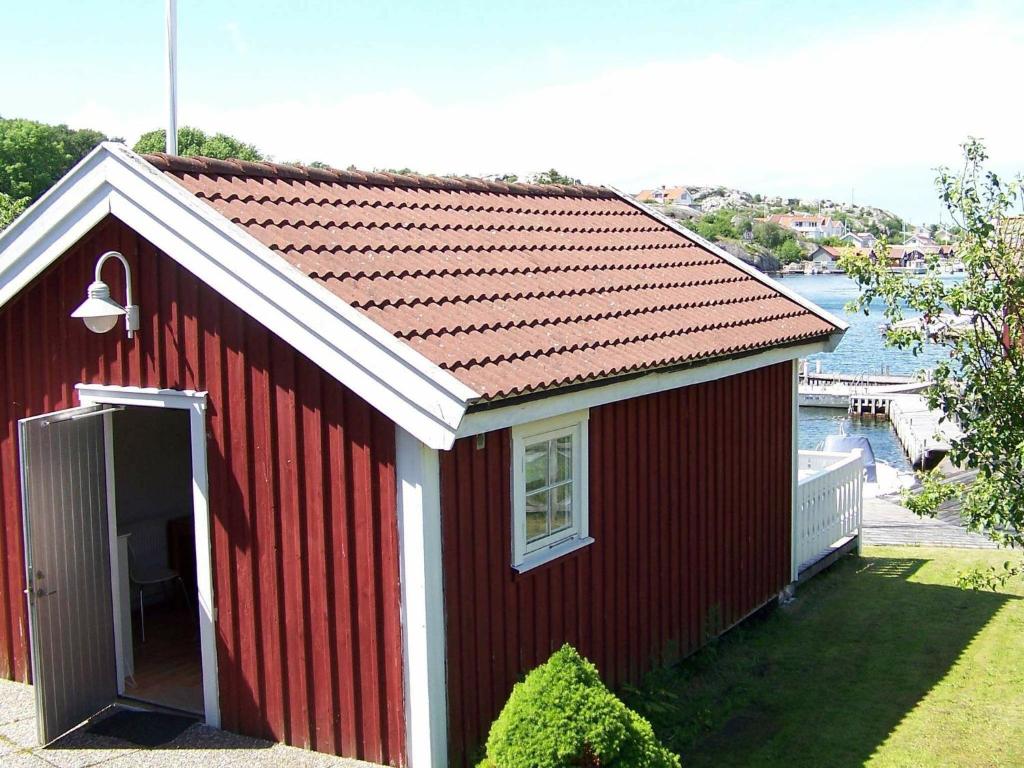 a red house with a red roof with a window at Holiday home in Rönnäng 1 in Rönnäng