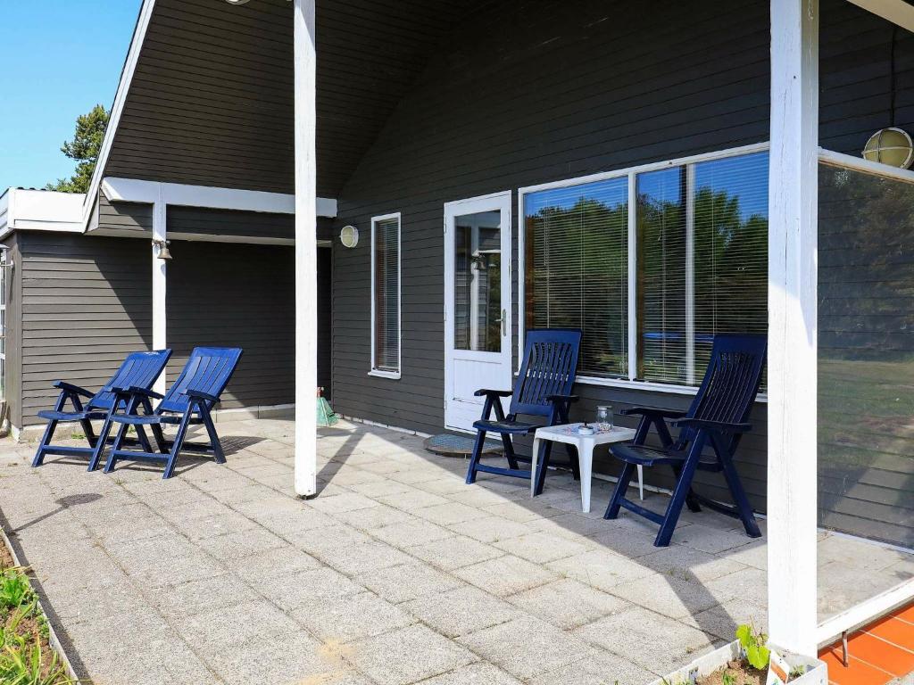 4 chaises bleues et une table sur une terrasse dans l'établissement 7 person holiday home in Hals, à Hals